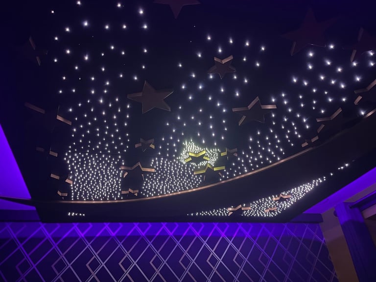 Ceiling view of a modern venue with thousands of white star-shaped lights and purple neon accents creating an illuminated canopy effect