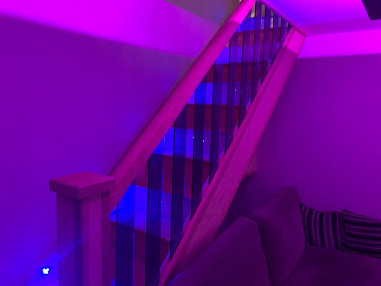 Neon-lit staircase with pink and blue LED lighting in a modern interior space